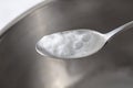 Foaming baking soda slaked with vinegar in a spoon over a metal dish