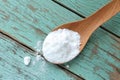 Baking soda (sodium bicarbonate) with wooden spoon on light blue wooden table. Royalty Free Stock Photo