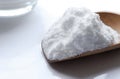 Baking soda (sodium bicarbonate) with wooden spoon on table. Royalty Free Stock Photo