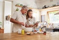 Baking, tablet and retirement with a senior couple cooking in the kitchen of their home together. Love, food and