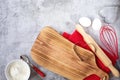 Baking theme for Valentine`s Day. Kitchen utensils, a cutting board and baked goods are on a gray background. Royalty Free Stock Photo