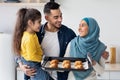 Baking Together. Happy Arab Family Of Three Holding Tray With Homemade Croissants