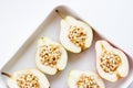 Baking tray with baked pears with honey and pine nuts