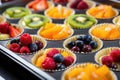 baking tray full of mini, fresh, fruit tarts