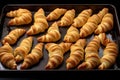 a baking tray full of unbaked dough in the shape of croissants