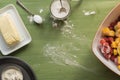 Baking utensils, flour, sugar, butter on green wooden surface