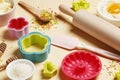 Baking utensils and ingredients. Colorful silicone cooking utensils, rolling pin, sugar sprinkling, whisk with cookie mold on a co