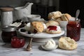 baking workshop with scones, jam, and clotted cream on a marble countertop