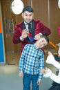 An illusionist and kids is holding a dove in his hands. The magician shows a performance . Focus-illusionist shows children