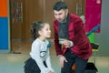 An illusionist and kids is holding a dove in his hands. The magician shows a performance . Focus-illusionist shows children