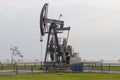 Oil pomp close up on the city embankment in the cloudy afternoon