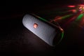 BAKU. AZERBAÃÂ°JAN Ã¢â¬â 28.07.2020: JBL Flip 4 Bluetooth Speaker close up shot on wooden table with colorful lights and fog on