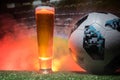 BAKU,AZERBAIJAN - JUNE 23, 2018 : Official Russia 2018 World Cup football ball The Adidas Telstar 18 and single beer glass on gras