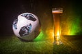 BAKU,AZERBAIJAN - JUNE 23, 2018 : Official Russia 2018 World Cup football ball The Adidas Telstar 18 and single beer glass on gree Royalty Free Stock Photo