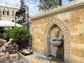 Baku, Azerbaijan, September, 09, 2019. Fountain with drinking water and Muse cafe on Kichik Gala street in the old town of Icheri
