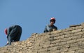 Men work on a brick wall in Baku, Azerbaijan