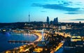 Baku at night. The capital city of Azerbaijan. Aerial panoramic cityscape view. Flame Towers, sea boulevard and street lights.