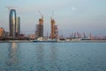 Baky skyline view from Baku boulevard the Caspian Sea embankment . Tall buildings in Baku. Ship cranes . Moon. harbor . Port
