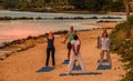 Unidentified adults participating in yoga on the beach