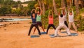 Unidentified adults participating in yoga on the beach