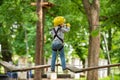 Balance beam and rope bridges. Little child climbing in adventure activity park with helmet and safety equipment. Cute Royalty Free Stock Photo