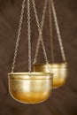 Balance concept, gold weighing scales on brown background Royalty Free Stock Photo