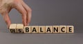 Balance or disbalance symbol. Businessman turns cubes and changes the word disbalance to balance. Beautiful grey background, copy