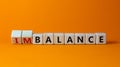 Balance or disbalance symbol. Turned cubes and changed the word disbalance to balance. Beautiful orange background, copy space.