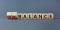 Balance or disbalance symbol. Turned cubes and changed the word disbalance to balance. Beautiful grey background, copy space.