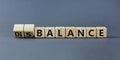 Balance or disbalance symbol. Turned cubes and changed the word disbalance to balance. Beautiful grey background, copy space.