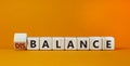 Balance or disbalance symbol. Turned cubes and changed the word disbalance to balance. Beautiful orange background, copy space.