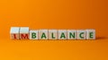 Balance or disbalance symbol. Turned cubes and changed the word disbalance to balance. Beautiful orange background, copy space.