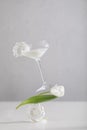 Balance food levitation creative still life. Balance of glass of liqueur, tulip and merengue on a light background.