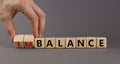 Balance or imbalance symbol. Businessman turns cubes and changes the word imbalance to balance. Beautiful grey background, copy