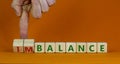 Balance or imbalance symbol. Businessman turns cubes and changes the word imbalance to balance. Beautiful orange background, copy