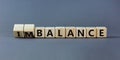 Balance or imbalance symbol. Turned cubes and changed the word imbalance to balance. Beautiful grey background, copy space.