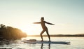 Balance is the key. an attractive young woman doing yoga on a paddle board on a lake outdoors. Royalty Free Stock Photo