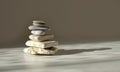 Balance pyramid stones on grey background, sunlight and shadows. Copy space