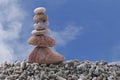 Balance stone on pile rock with blue sky background.