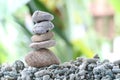 Balance stone on pile rock with garden background.