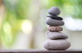 Balance Stones stacked to pyramid in the soft green background.