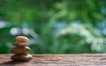 Balance Zen stones on wood with green nature bokeh background. Royalty Free Stock Photo