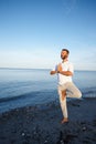 Balanced on the beach. Full length shot of a handsome mature man doing yoga on the beach. Royalty Free Stock Photo