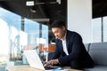 Balanced and calm businessman, asian man thinking working at laptop sitting in the office by the window Royalty Free Stock Photo