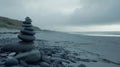 Balanced Dark Grey Stones Stack on Wet Black Sand Beach Under Cloudy Sky Royalty Free Stock Photo
