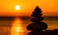 Balanced pebble pyramid silhouette on the beach. Abstract warm sunset bokeh with Sea on the background. Zen stones on the sea Royalty Free Stock Photo