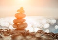 Balanced Pebbles Pyramid on the Beach on Sunny Day and Clear Sky at Sunset. Blue Sea on Background. Selective focus, Bokeh. Zen Royalty Free Stock Photo