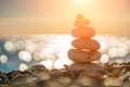 Balanced Pebbles Pyramid on the Beach on Sunny Day and Clear Sky at Sunset. Blue Sea on Background Selective focus, zen stones on Royalty Free Stock Photo