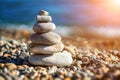 Balanced Pebbles Pyramid on the Beach on Sunny Day and Clear Sky at Sunset. Blue Sea on Background Selective focus, zen stones on Royalty Free Stock Photo