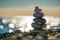 Balanced Pebbles Pyramid on the Beach on Sunny Day and Clear Sky at Sunset. Blue Sea on Background Selective focus, zen stones on Royalty Free Stock Photo